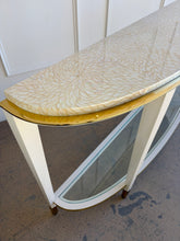 Load image into Gallery viewer, Angled right detail view of the Judith Leiber console by Theodore Alexander, highlighting the demi-lune shape, white lacquer finish, and polished brass edge beneath the pearl effect top
