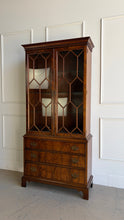 Load image into Gallery viewer, A true heirloom piece from Hickory Chair, this cabinet showcases everything that defines high-end traditional furniture—exceptional materials, precise craftsmanship, and timeless design. The case is wrapped in beautifully bookmatched crotch mahogany veneer, creating dramatic movement across the drawer fronts, while the glazed doors feature geometric muntins that give the piece a tailored, architectural feel. Good Bones Furniture
