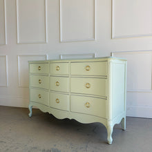 Load image into Gallery viewer, Side view of a vintage French dresser with a painted green finish and gently curved profile.
